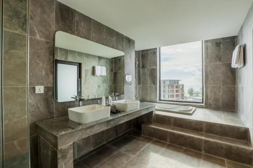 a bathroom with two sinks and a large mirror at Otres Beach Hotel in Sihanoukville