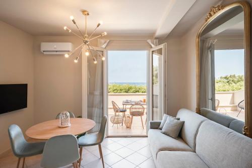 - un salon avec un canapé et une table dans l'établissement Zefiro Apartments, à San Vincenzo