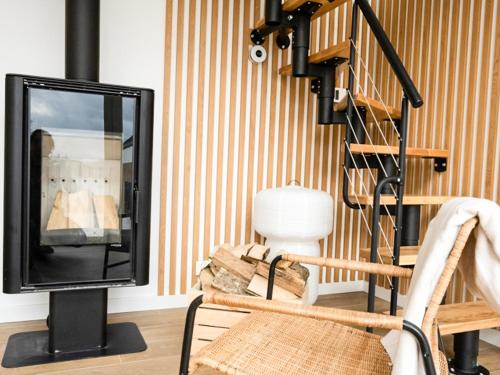a living room with a television and a chair at Warmiński Sad in Olsztyn
