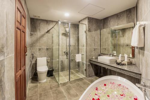 a bathroom with a shower and a toilet and a sink at Otres Beach Hotel in Sihanoukville