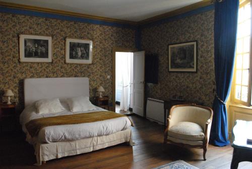 um quarto com uma cama e uma cadeira em Le Ragois em Richelieu
