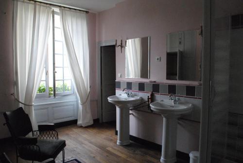 a bathroom with two sinks and a window at Le Ragois in Richelieu