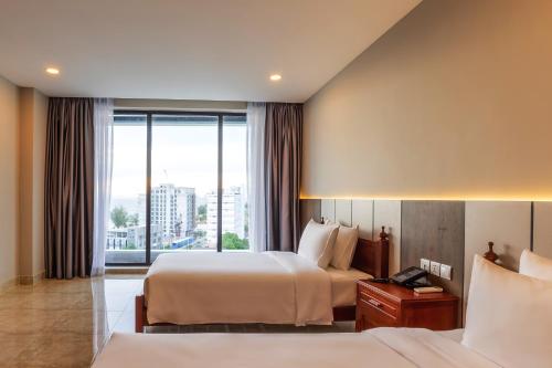 a hotel room with two beds and a window at Otres Beach Hotel in Sihanoukville