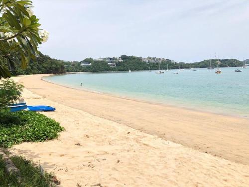 a sandy beach with a blue surfboard on it at 1 bedroom Villa on Ao Yon beach with sea views in Phuket Town