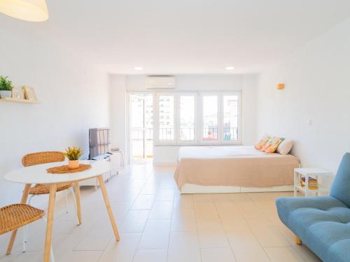 een slaapkamer met een bed, een tafel en een bank bij Cubo's Fuengirola Leisure Port in Fuengirola