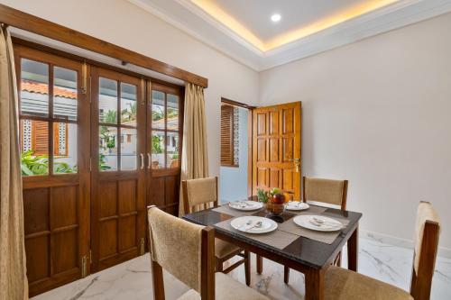 a dining room with a table and chairs at Leoney Resort Goa in Vagator