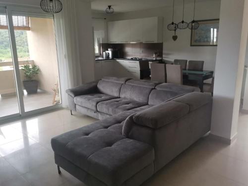 Apartman Ana في راب: غرفة معيشة مع أريكة ومطبخ