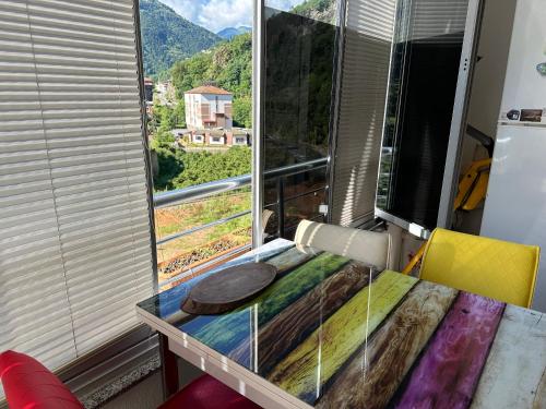 een kamer met een tafel en een raam met uitzicht bij Uzungöl city evleri in Dernekpazarı
