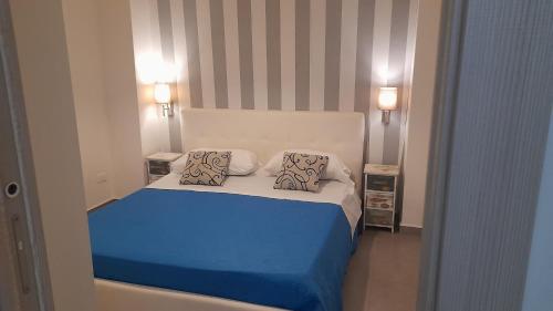 a bedroom with a blue bed with two pillows at I Faraglioni Comfort Rooms in Terrasini