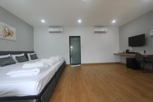 a bedroom with a large bed and a flat screen tv at The Mira Hotel Chiang Rai in Chiang Rai