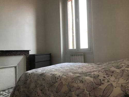 um quarto com uma cama com um edredão e uma janela em Appartement vue mer, carré d’or ,150 m plages. em Saint-Raphaël