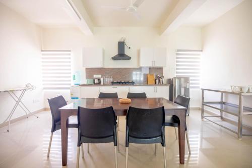 a kitchen with a wooden table and black chairs at Neemtree Apartments in Hyderabad