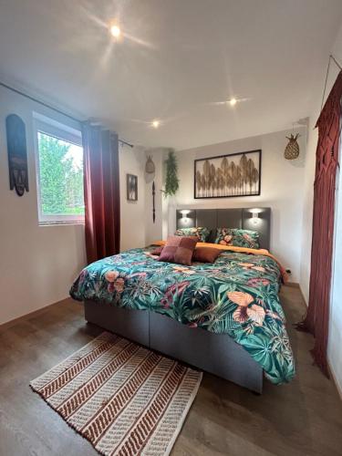 a bedroom with a large bed with a colorful comforter at L'échappée Belle by J&J Durbuy Area in Clavier