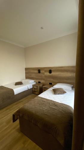 two beds in a room with at Гостинично-банный комплекс PARADISE in Shchūchīnsk