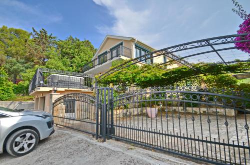 a car parked in front of a gate in front of a house at Kjara Lux Apartment in Tivat
