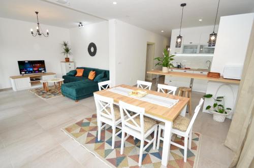 a kitchen and living room with a table and chairs at Kjara Lux Apartment in Tivat
