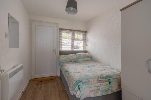 a small bedroom with a bed and a window at Lundy Sea View Villa - Mobility friendly in Bideford