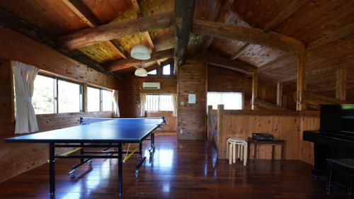 - une table de ping-pong dans une pièce dotée de murs en bois dans l'établissement Villa Tora, à Onna