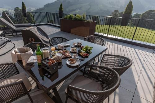 a table with food and drinks on a balcony at Biohof Ebengut in Maria Alm am Steinernen Meer