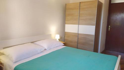 a bedroom with a bed and a cupboard at Apartments Samodol in Vodice