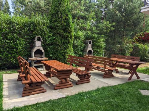 a group of benches and a table and a bell at DELFIN Wynajem Pokoi in Ostrowo