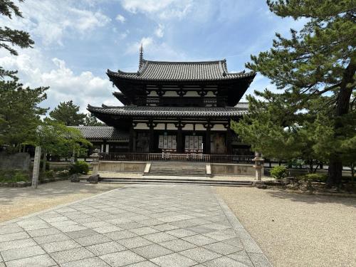 a large building with a roof in a park at Ryokan Kousen Kazeya Group in Nara