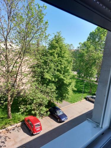 a window view of two cars parked on a street at Stan-apartman A&A in Banja Luka