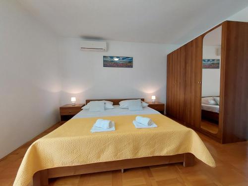 - une chambre avec un lit et 2 serviettes dans l'établissement Apartmani Rahela, à Vodice