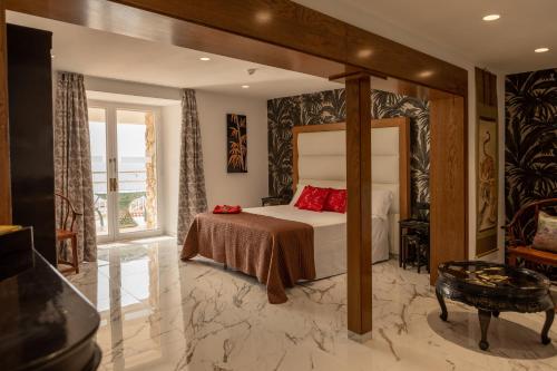 a bedroom with a bed and a large window at Hotel Roger de Flor by Seleqtta in Lloret de Mar