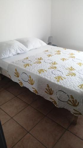 uma cama com um cobertor branco com flores em Villa Vias Plage em Vias