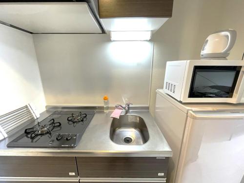 a kitchen with a stove and a microwave and a sink at Credo Maison Kamakura - Vacation STAY 10395 in Kamakura