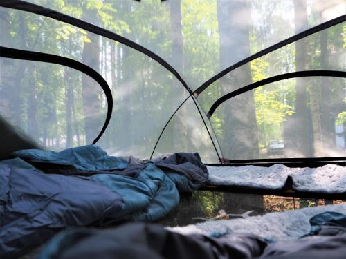 ein Zelt mit einem Schlafsack in einem Wald in der Unterkunft LevonMajat in Joensuu