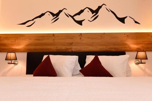 a bedroom with a bed with mountains on the wall at Hotel Die Montafonerin in Vandans