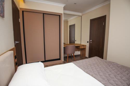 a bedroom with a bed and a desk and a table at Chagala Residence Atyrau in Atyraū