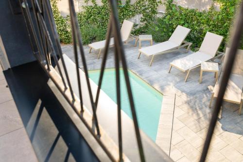 a view of a swimming pool with white chairs and a pool at Villa Jazz - Island Krk SPA Oasis in Krk