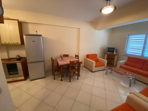 uma cozinha e sala de estar com mesa e cadeiras em Vlora Lungomare Apartment, above Bar Bonaparte em Vlorë