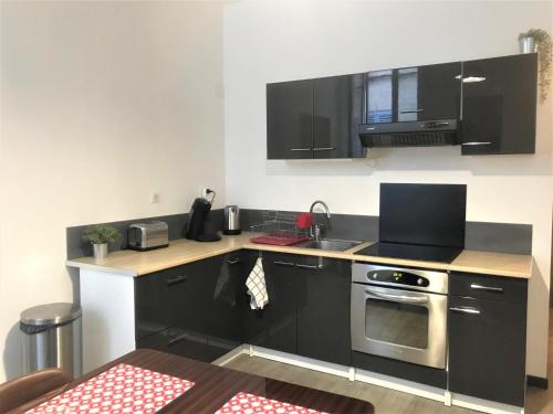 une cuisine avec un évier et une cuisinière four supérieur dans l'établissement Grand appartement 4 couchages la Ciotat près de tout, à La Ciotat