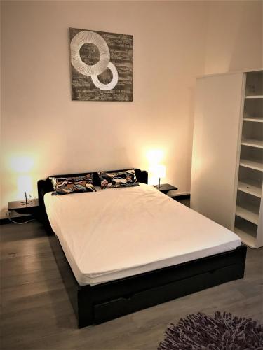 Ce lit se trouve dans un dortoir doté de 2 lampes et d'une photo murale. dans l'établissement Grand appartement 4 couchages la Ciotat près de tout, à La Ciotat