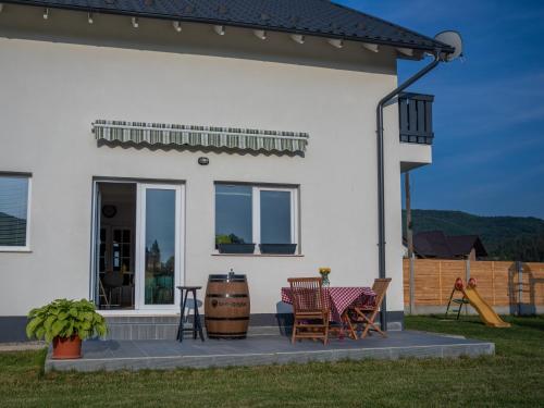 a white house with a table and chairs on a patio at DOM HILLS Bucovina in Gura Humorului
