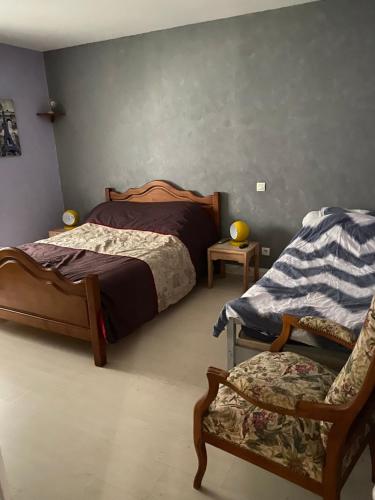 a bedroom with two beds and a chair at Loue maison quartier calme in Royan