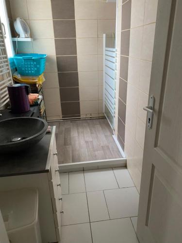 a bathroom with a shower with a sink and a door at Loue maison quartier calme in Royan