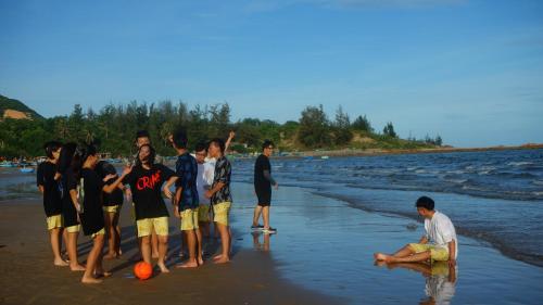 a group of people standing on the beach at Stop And Go Lang Chai Boutique Resort in Phan Thiet