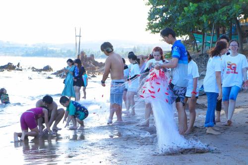a group of people on the beach playing in the water at Stop And Go Lang Chai Boutique Resort in Phan Thiet