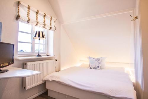 um pequeno quarto com uma cama e uma janela em Haus-Munkhoog em Munkmarsch