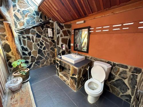 La salle de bains en pierre est pourvue de toilettes et d'un lavabo. dans l'établissement JERPORDEE Residence, à Ko Chang