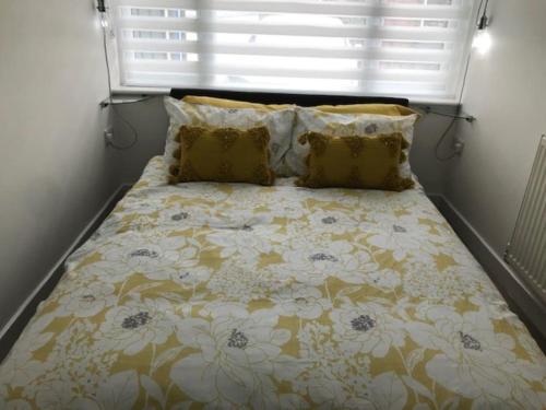 a bedroom with a bed with a flowery comforter at Dolly Cottage Colchester in Mile End