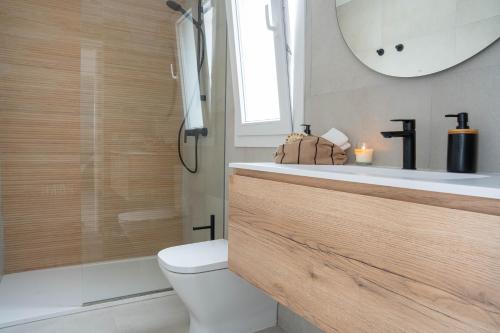 a bathroom with a toilet and a sink and a mirror at Villas Rymar in Cala en Bosc