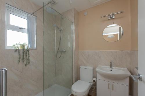 a bathroom with a shower and a toilet and a sink at Leeway Lodge in Church Coppenhall