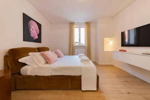 a bedroom with a bed and a flat screen tv at Suites7 in San Donato di Lecce