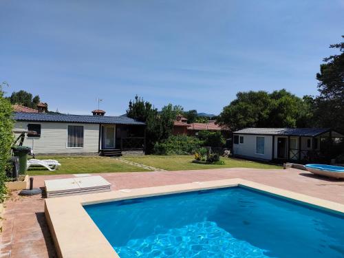 una piscina en el patio trasero de una casa en Naturalayos I y Naturalayos II - casas para parejas - jacuzzi, en Pelayos de la Presa